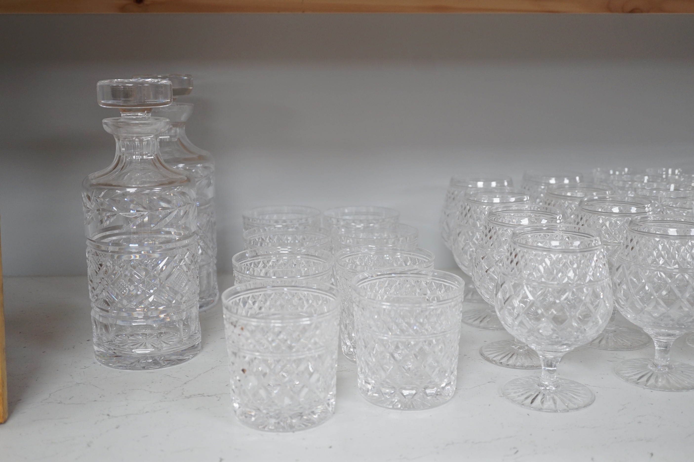 A quantity of Stuart cut glass suite of wine and spirit glasses and a similar pair of decanters